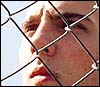 Man's face behind a fence