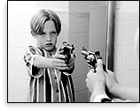 Boy holding gun at self in a mirror